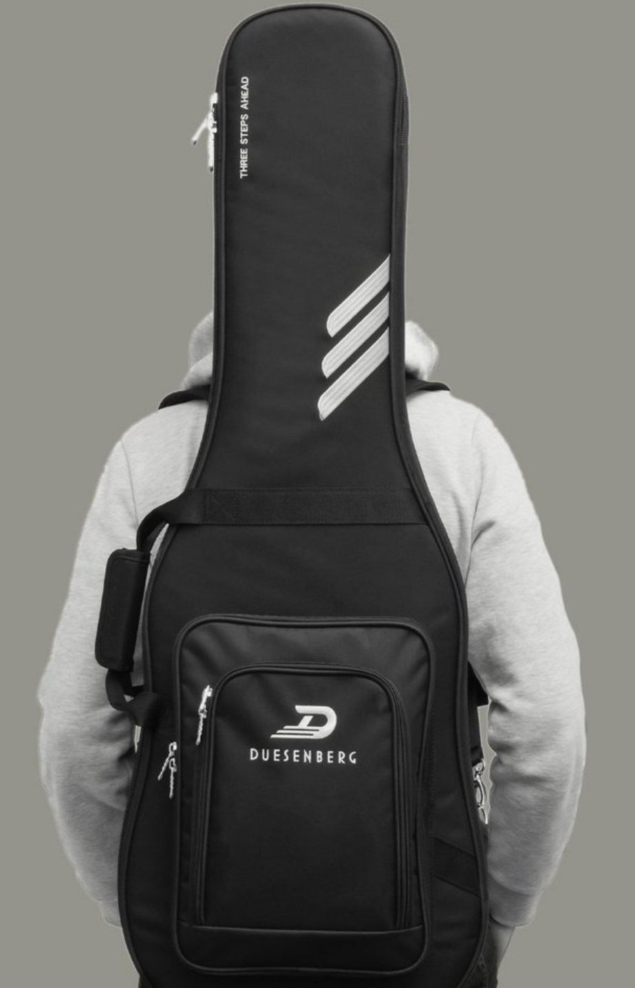 A sleek black gig bag designed for ultimate protection and comfort, effortlessly carried on the back of a guitarist. Perfectly crafted to combine functionality and style, it ensures your instrument is safe and ready to travel wherever the music takes you.