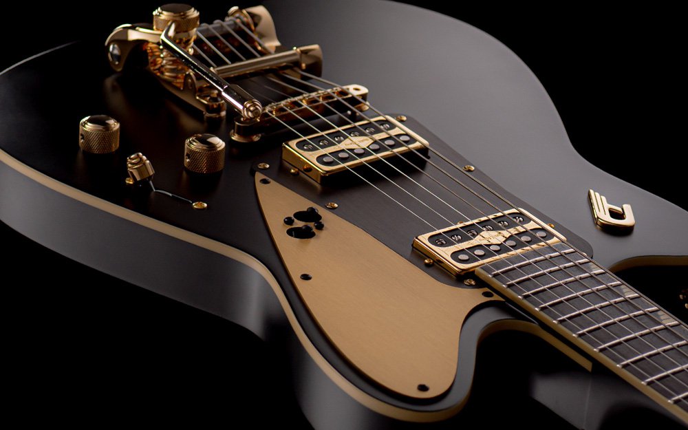 Close-up view of a Duesenberg electric guitar showcasing its bold black matte finish and luxurious gold accents. The intricate details highlight the guitar's premium craftsmanship and elegant design.
