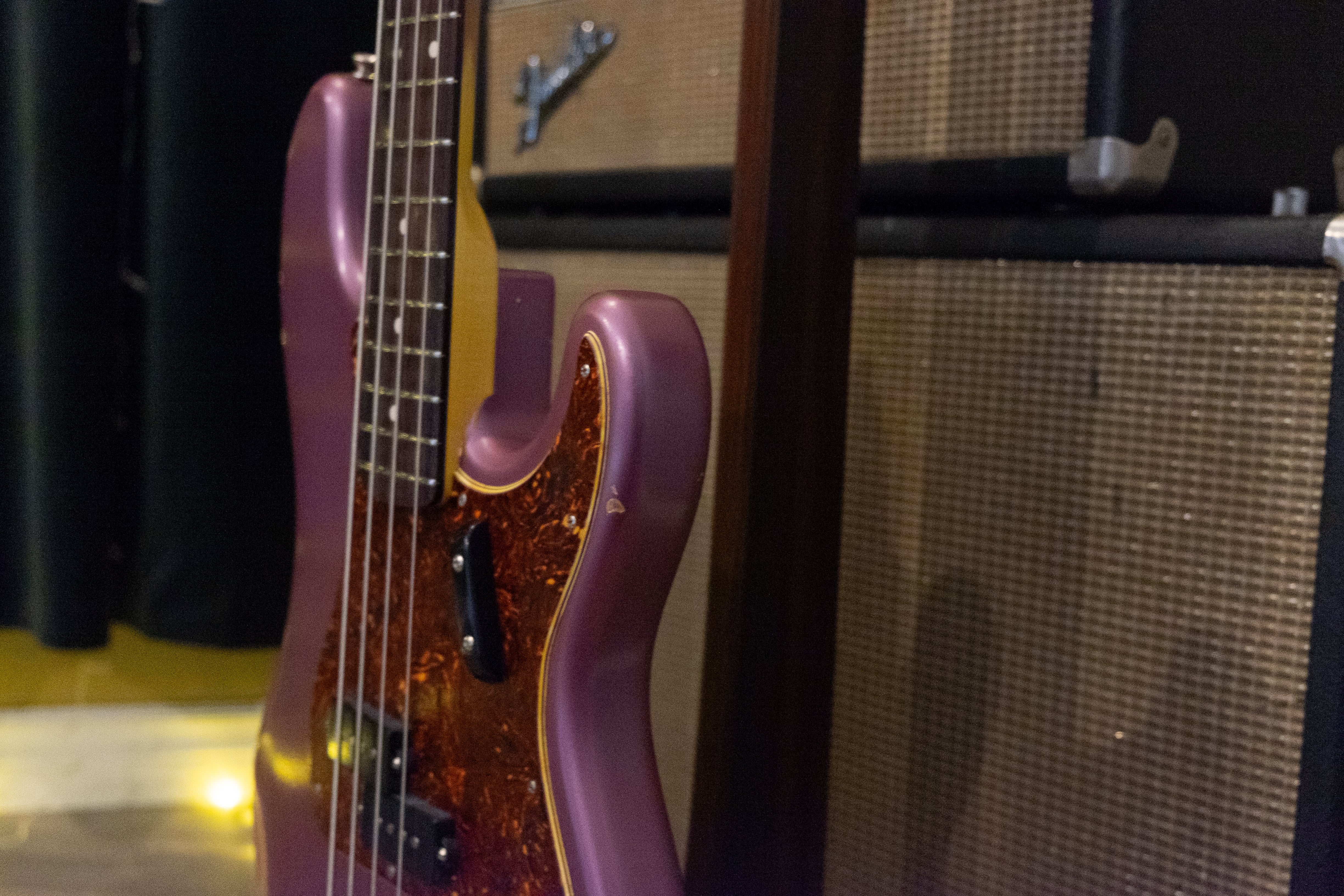 Close-up of Nash PB63 bass in Burgundy Mist with a wooden neck and four strings.