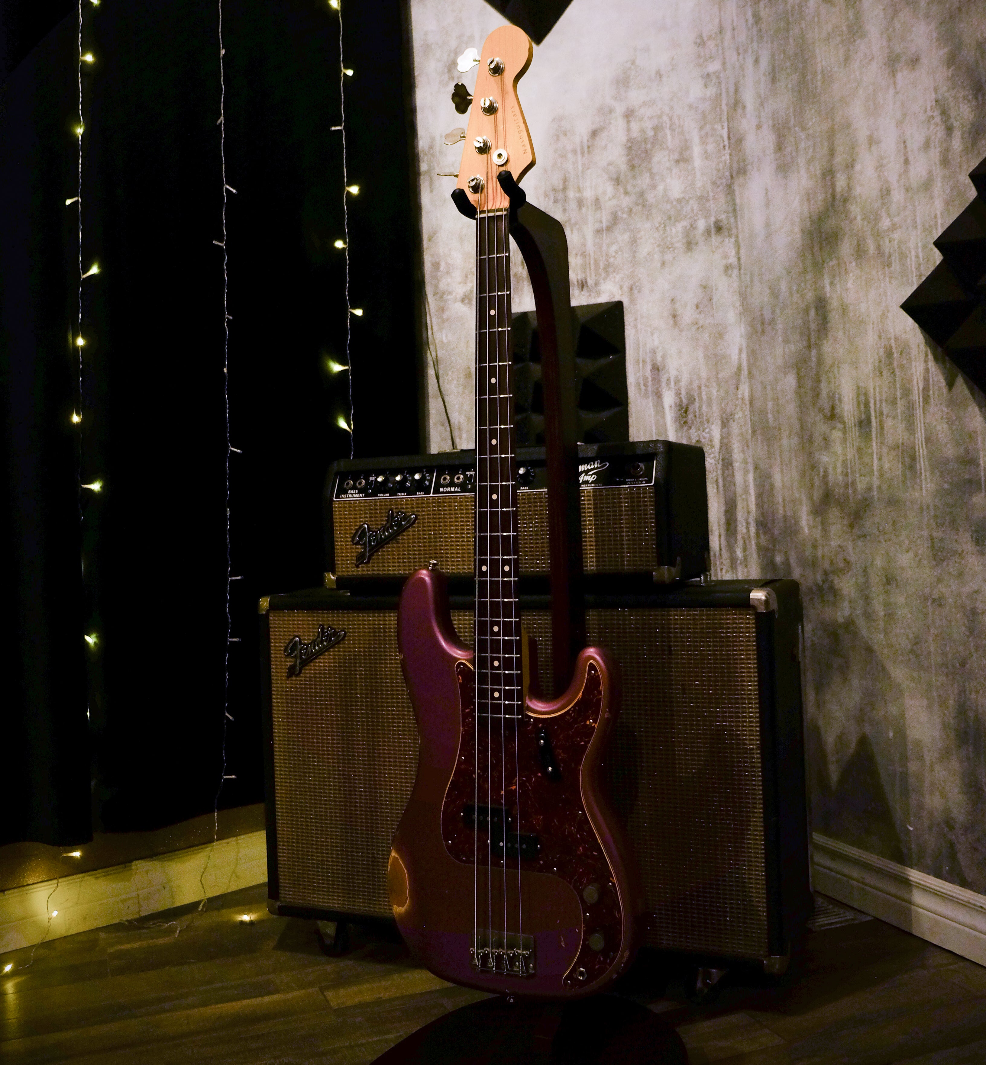 Nash PB63 bass in Burgundy Mist, leaning against a vintage Fender amp.