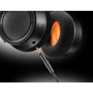 Close-up of the Neumann NDH 20 headphone earcup showing the detachable audio cable connection and orange 'L' indicator inside the ear pad.