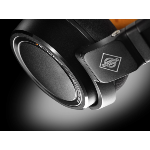 Close-up of the Neumann NDH 20 studio headphones, showcasing the sleek black earcup design with the Neumann logo and precision-engineered build