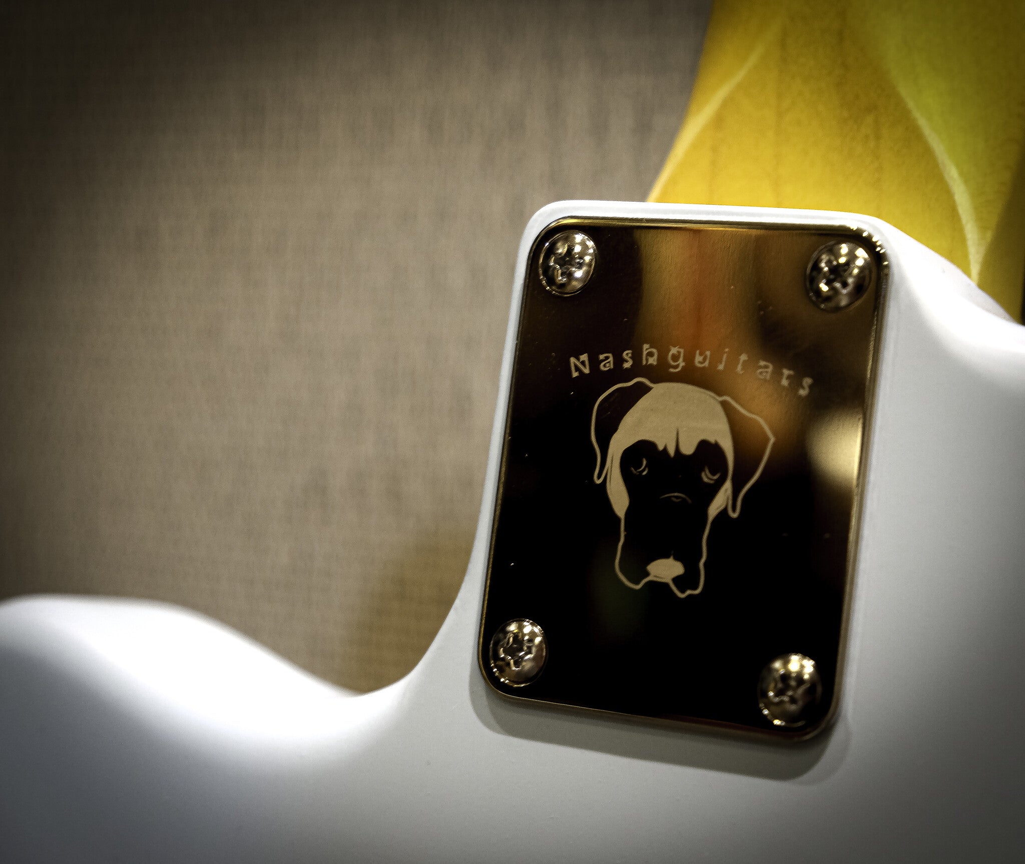 Back of a Nash electric guitar with the Nash Guitars dog logo engraved on the body, showcasing its unique design and craftsmanship.