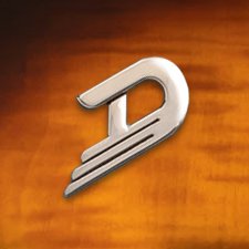 The iconic Duesenberg logo elegantly displayed against a polished wooden background, reflecting premium craftsmanship and timeless design.