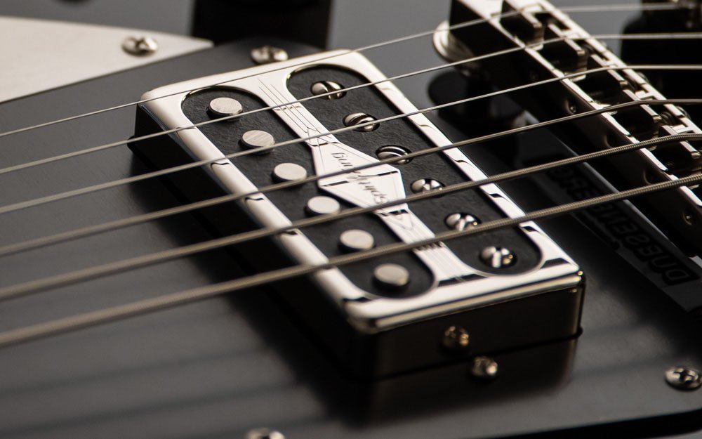 "Close-up of a black electric guitar, highlighting the strings and the pickup. The sleek black finish and precise craftsmanship emphasize the guitar's modern and stylish design.